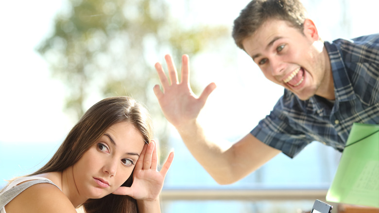 man waving at woman