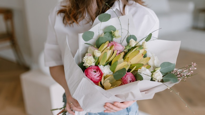 woman presenting bouquet of flowers