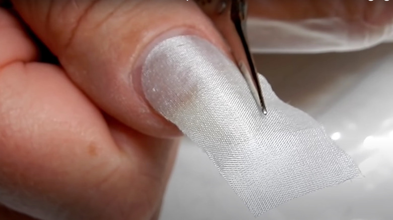 woman applying silk wrap nail