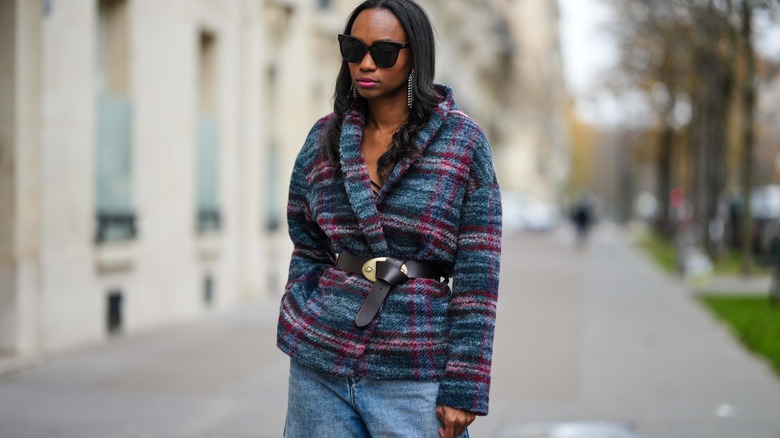 woman wearing jacket with belt and glasses