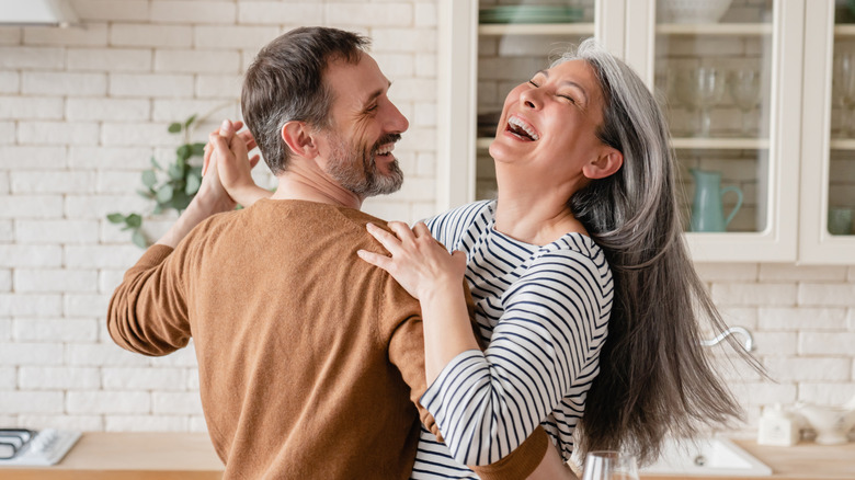 Mature couple dancing in kitchen