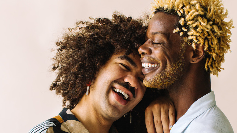 Smiling gay couple embracing