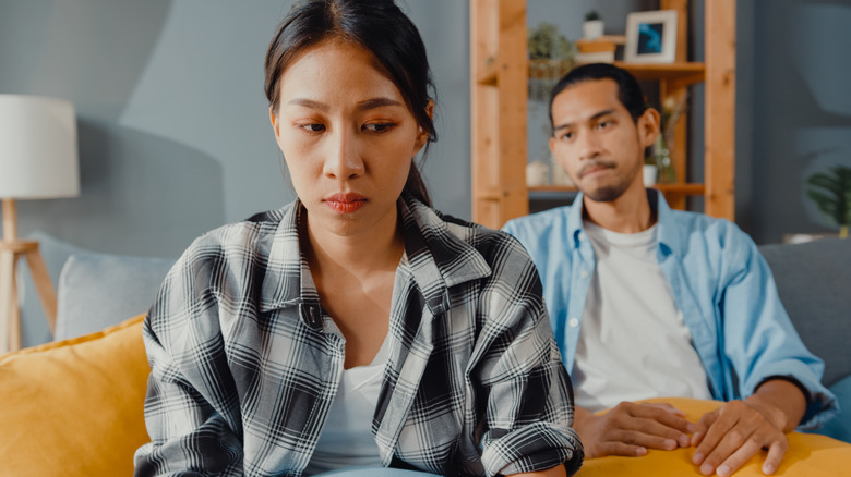 Couple appears unhappy on sofa