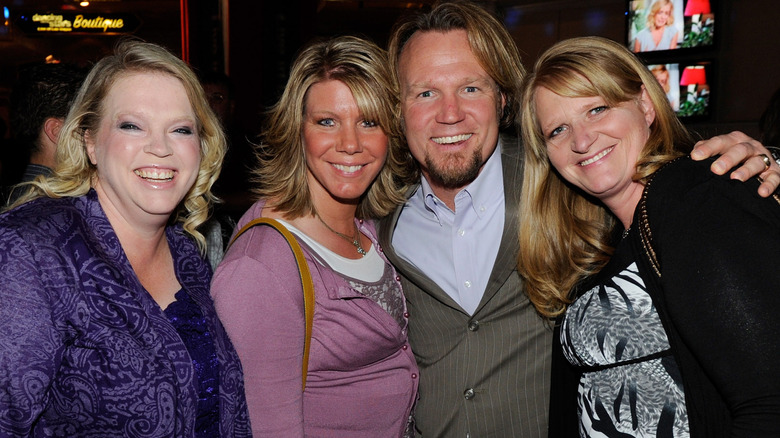 Sister Wives stars Janelle, Meri and Chirstine Brown flank Kody Brown while smiling