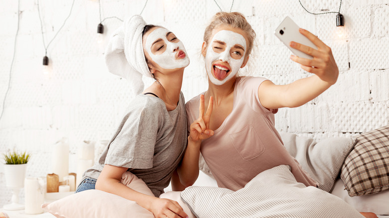 Two women wearing face masks posing for selfie