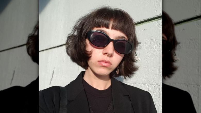 Woman with ashy brown baby bangs