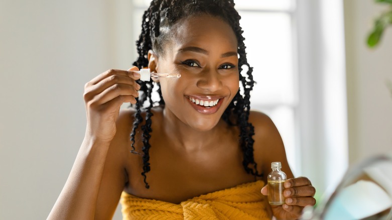 woman applying serum to skin