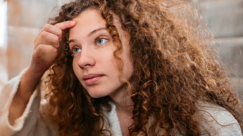 Woman looking at a zit