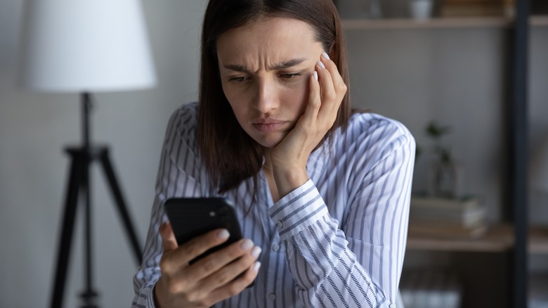Woman scowling at cell phone