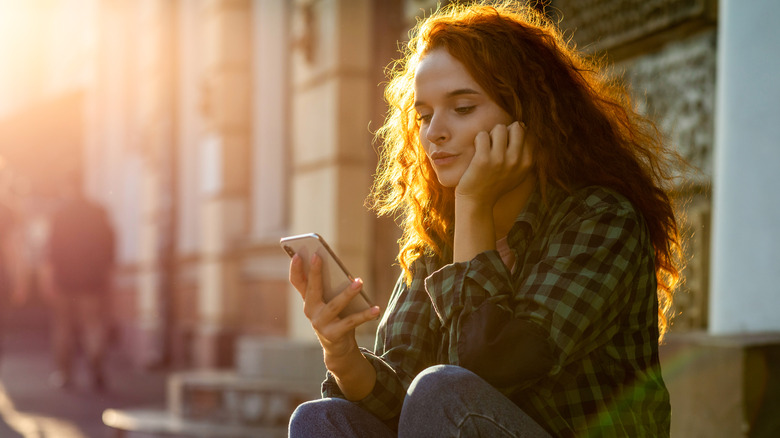 upset woman looking at phone