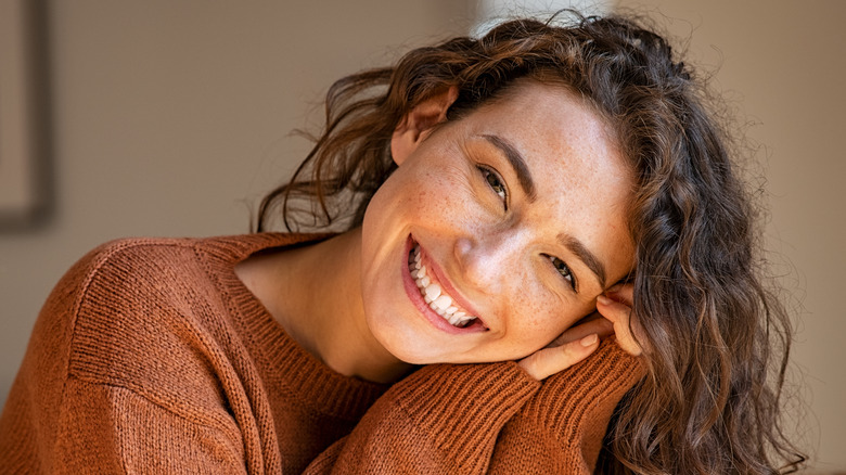 Woman smiling in brown sweater