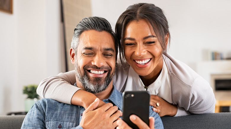 happy couple looking at phone 