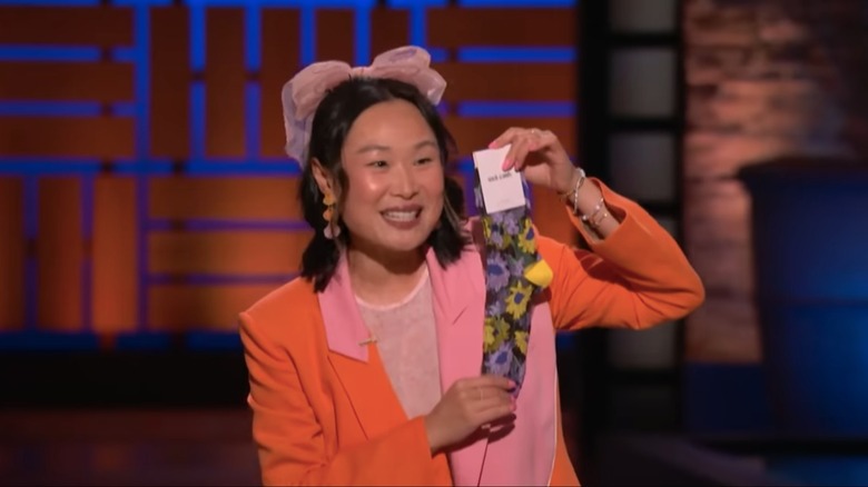 Sock Candy founder Mary Gui on "Shark Tank" holding a pair of her fashion socks