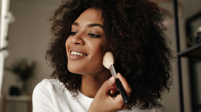 woman using contour makeup brush