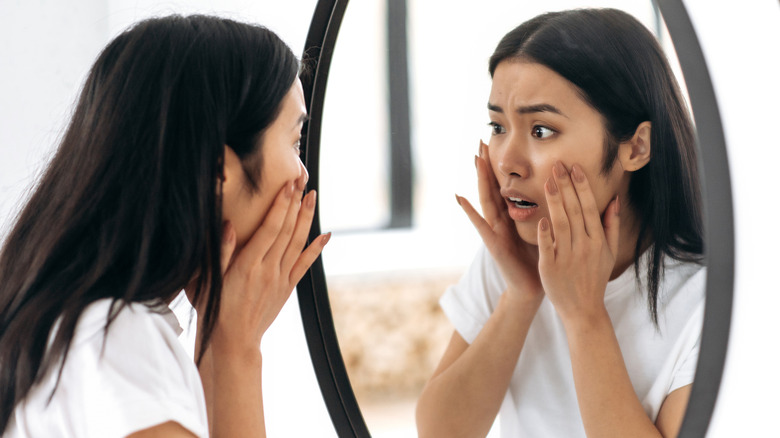 young woman looking in mirror