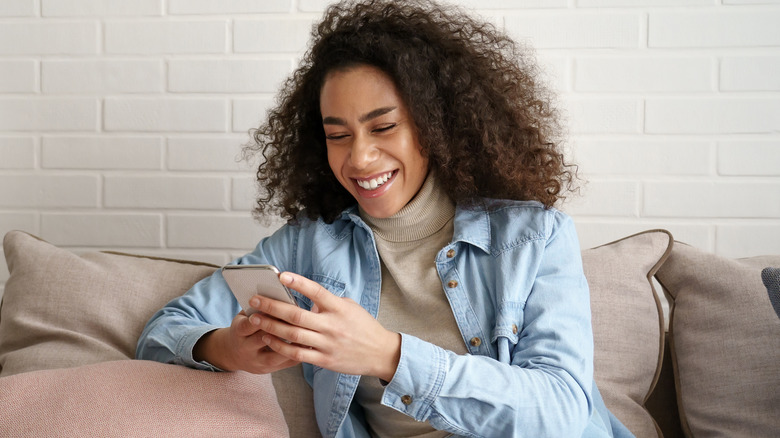 woman smiling and holding phone