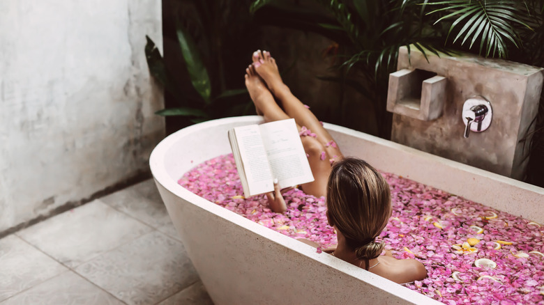 Woman in tub with rose petals