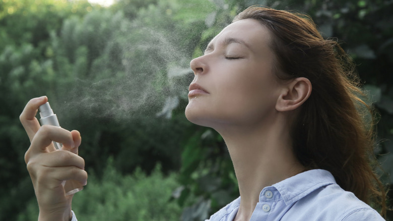 Woman spraying misting skincare on