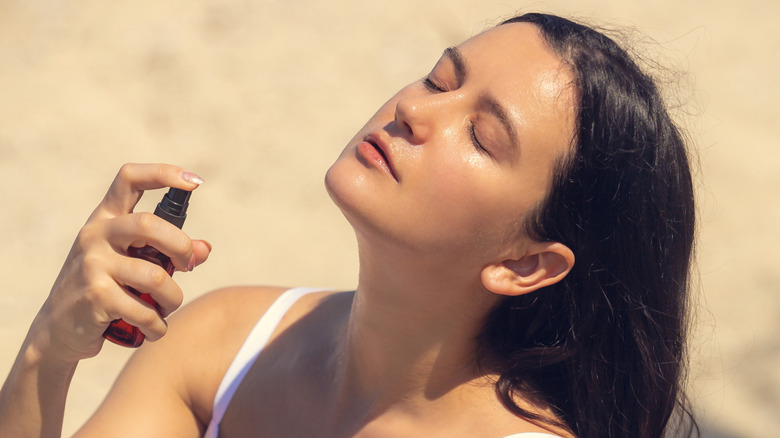 Close up of woman spraying on skincare