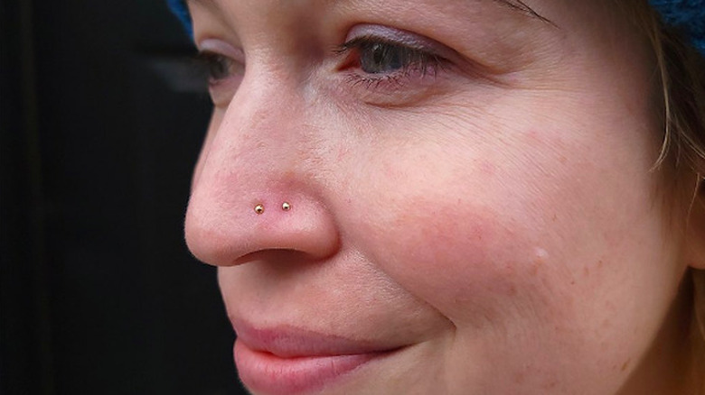 Person with many face piercings