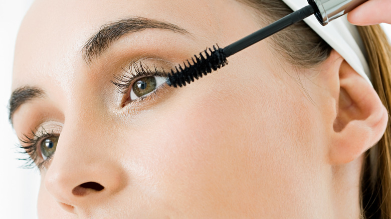 Woman applying mascara