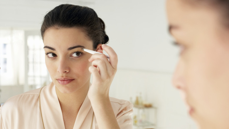 woman putting eyebrow makeup on