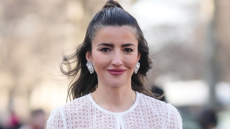 A woman wearing silver statement earrings