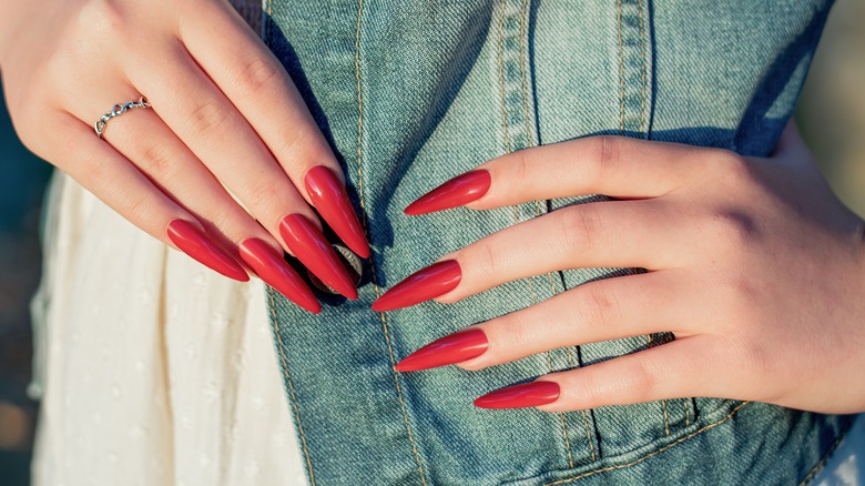 Woman's hands with red stiletto nails