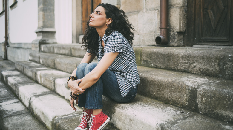 anxious woman sitting on step