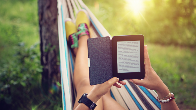 person reading e-book on hammock