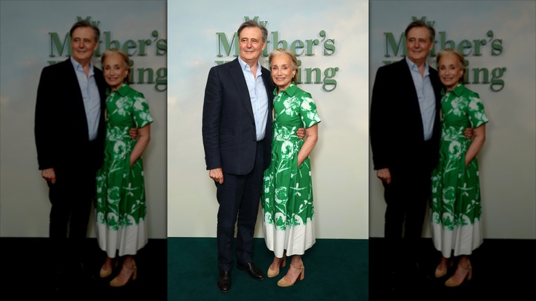 John Micklethwait (L) wearing a suit next to Kristin Scott Thomas (R) wearing a floral green dress
