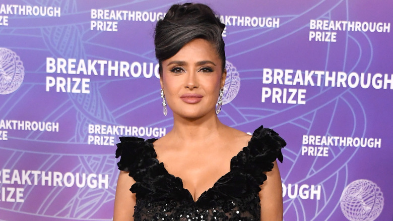 Salma Hayek in a black dress and an elegant updo with her grays showing