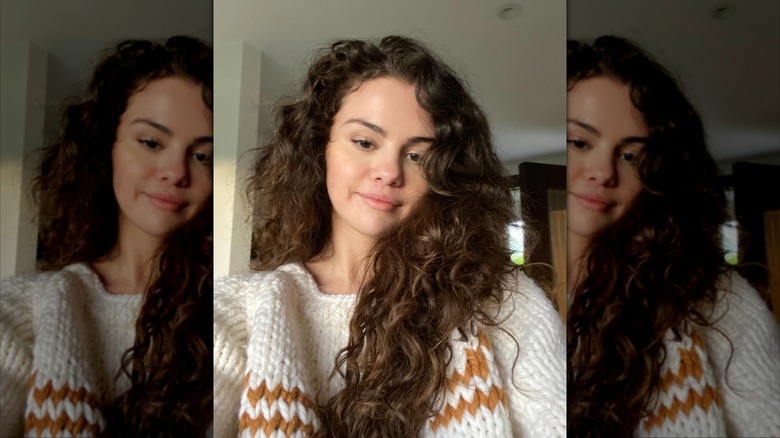 Selena Gomez smiles in a knit sweater