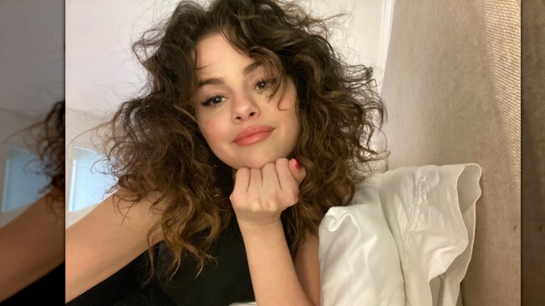 Selena Gomez smiles in a selfie in bed