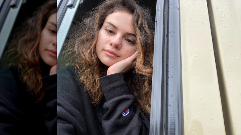 Selena Gomez poses for a picture by a window