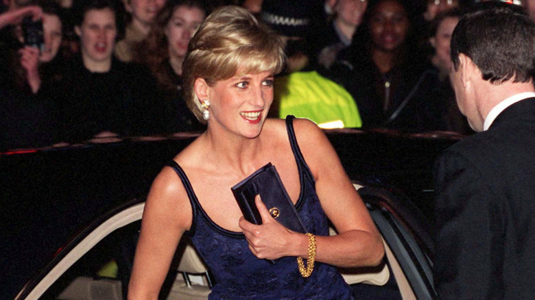 Princess Diana exiting a car with a navy clutch held against her chest