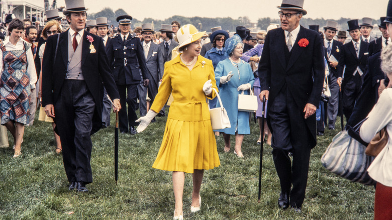 Queen Elizabeth walking in a yellow skirt suit