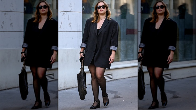 A woman wearing a blazer with rolled up sleeves