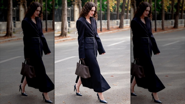 A woman weaing a skinny belt over a coat dress