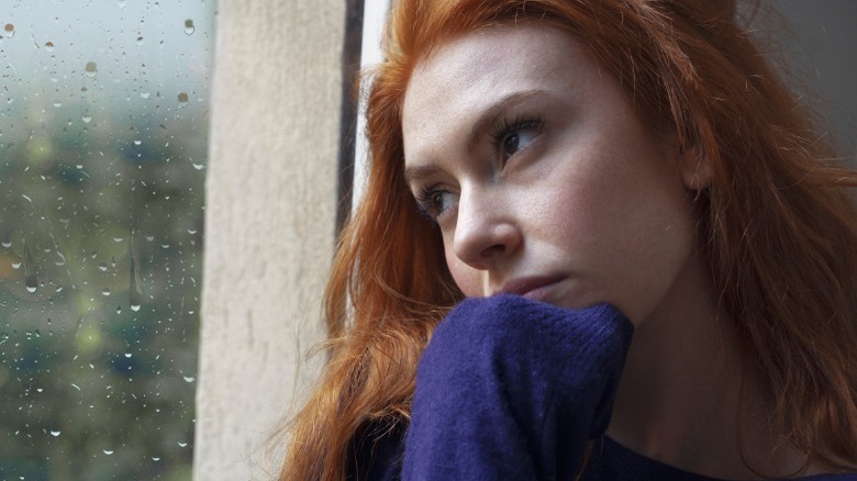 Sad woman looking out window