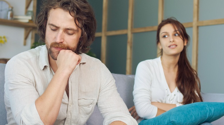 concerned man with smirking girlfriend