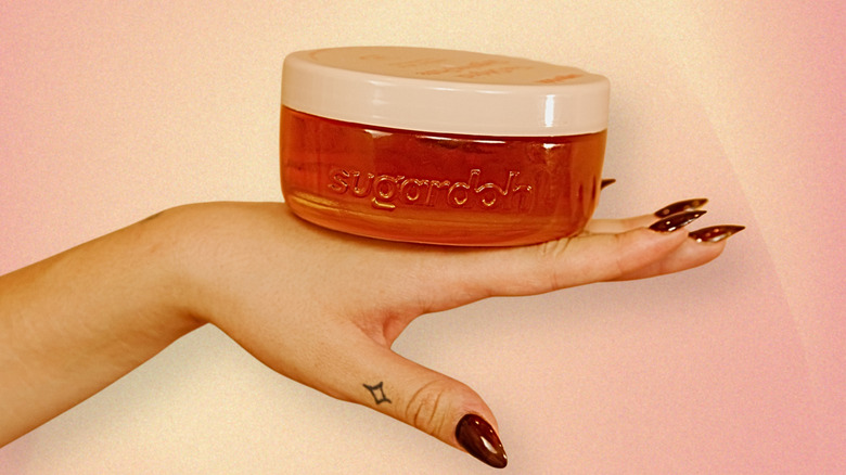 A jar of Sugardoh's "Big Doh" sitting on top of a model's hand