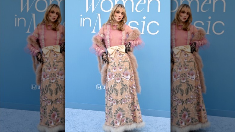 Suki Waterhouse poses on the blue carpet at an awards show