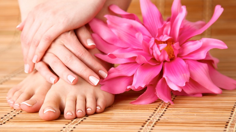 A woman with a french tip manicure and matching pedicure.