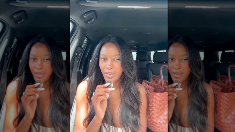 Ciara Miller speaking with naturally wavy hair in the car