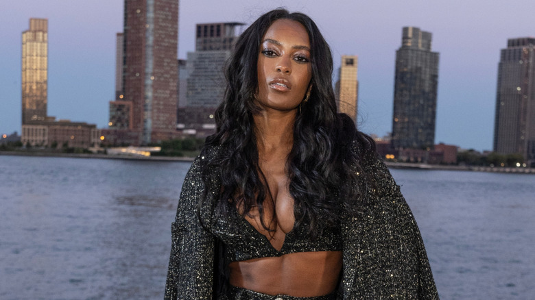Ciara Miller posing with curly hair in front of the Hudson River