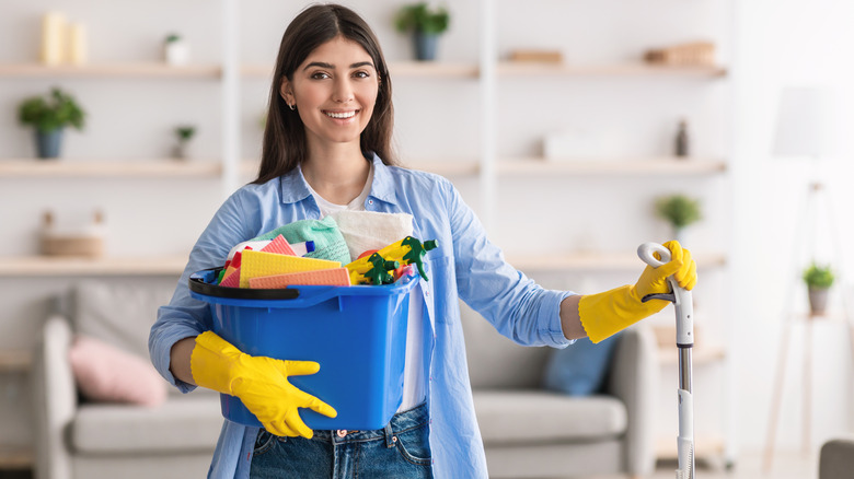 Woman smiling with cleaning supplies