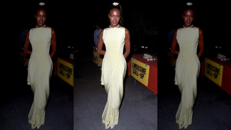 Naomi Campbell wearing a light-yellow boatneck gown.