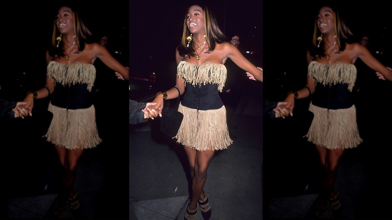 Naomi Campbell wearing a black and beige fringe dress.