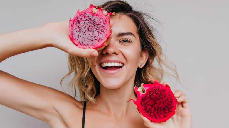 Woman holds dragon fruit 